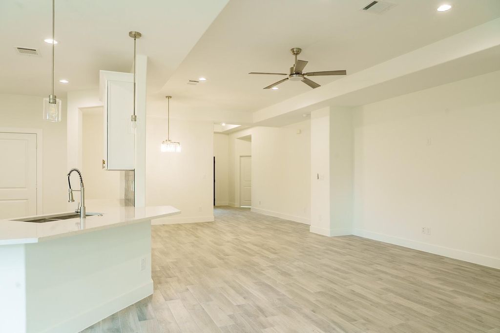 Open living area with a ceiling fan, next to the kitchen island