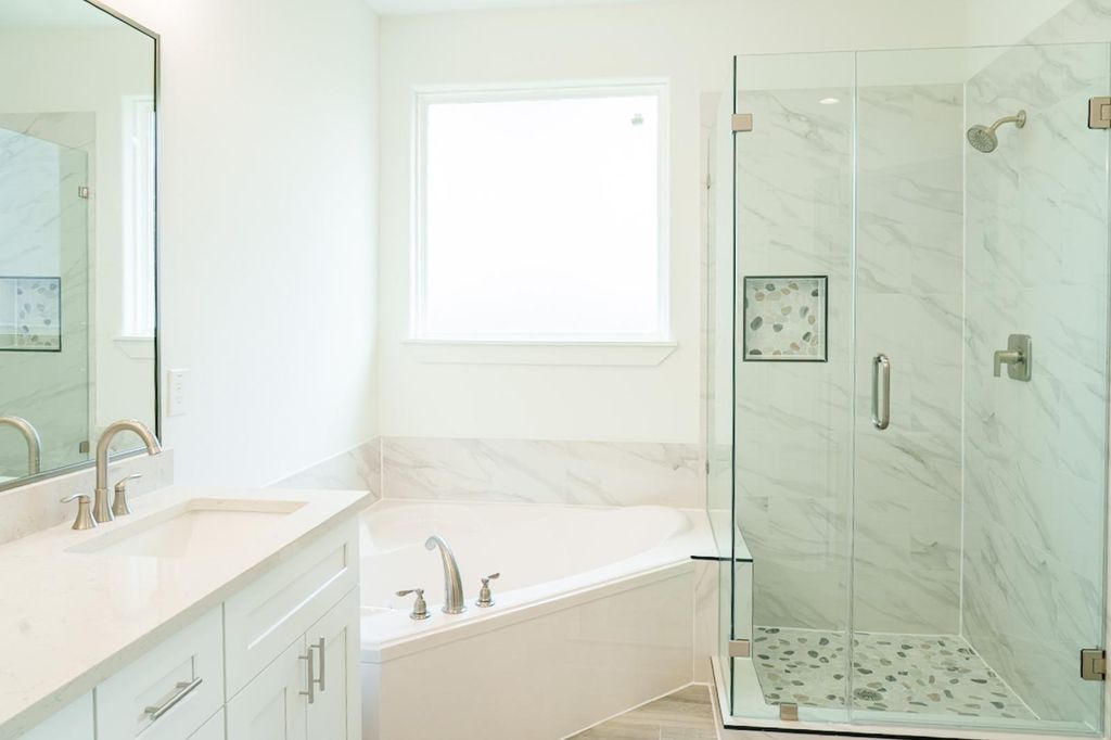 Primary bath with a tub and a glass shower