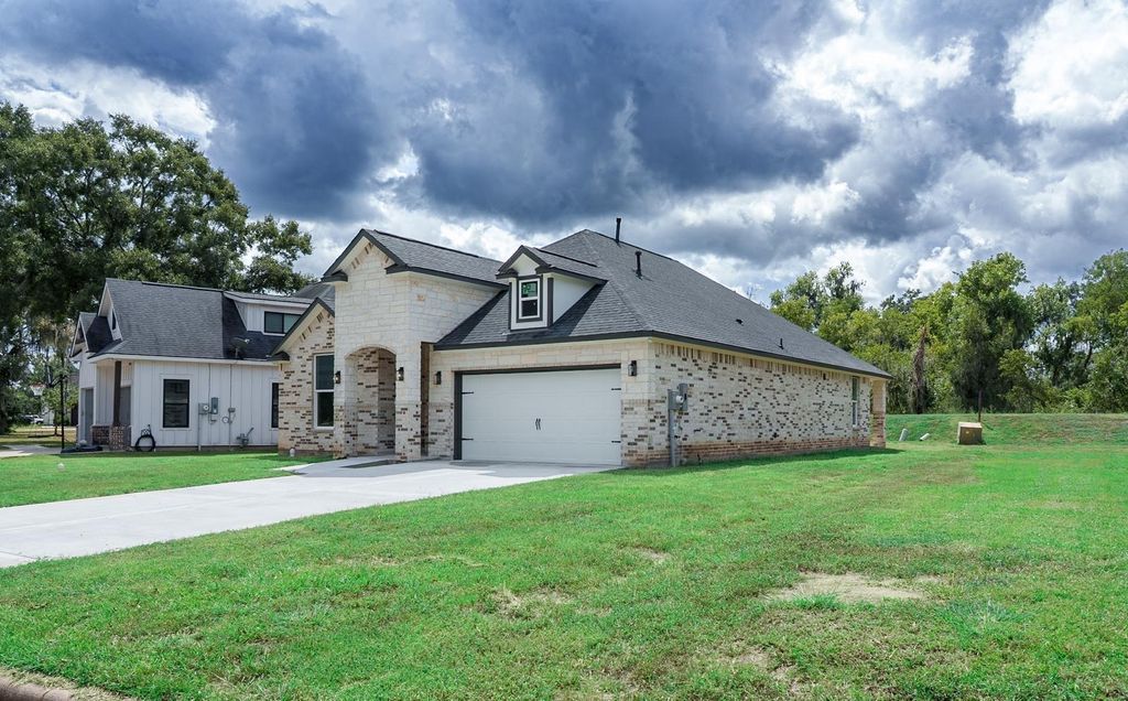 Side view of the brick and stone home and its two-car garage