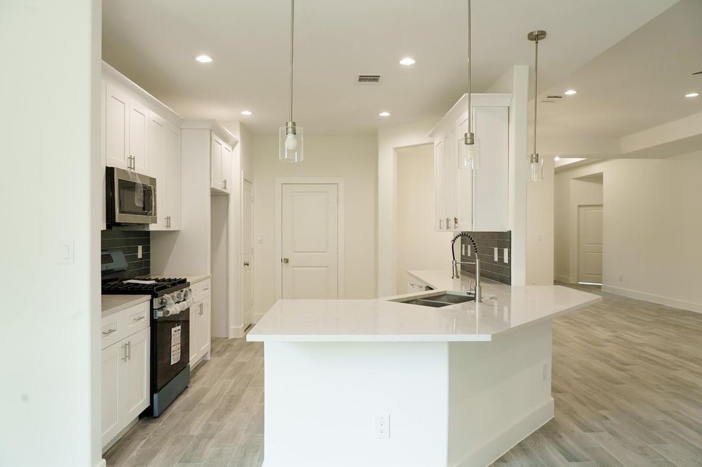 Kitchen island with a sink and pendant lights